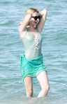 Emma Roberts on the beach in a wet swimsuit