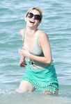 Emma Roberts on the beach in a wet swimsuit
